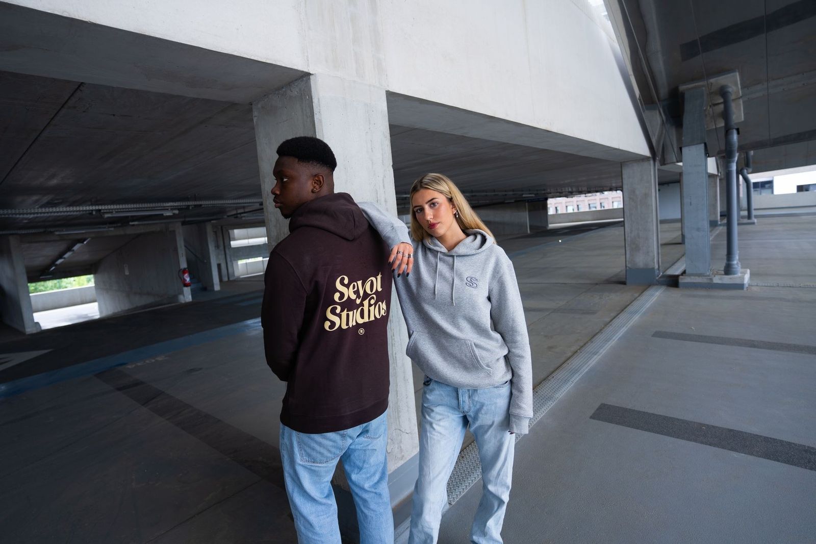 Fashionable pair in streetwear style captured in a modern urban setting.